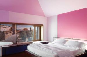 サンタンブロージョ・ディ・ヴァルポリチェッラにあるLa Grande Casa Valpolicellaの大きなベッド付きのベッドルーム1室、壁に絵画が飾られています。