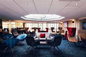 a living room filled with chairs and tables at Novotel Nottingham Derby in Long Eaton