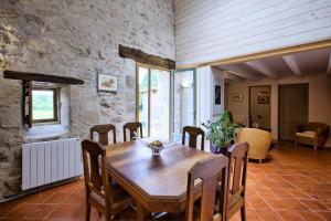 a dining room with a wooden table and chairs at La Grange d'Oustaud in Vérac