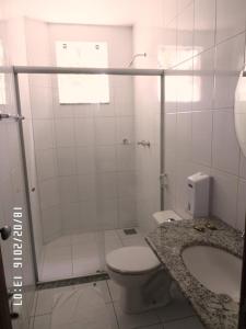 a bathroom with a toilet and a shower and a sink at Hotel Pinheiros in Chonim de Baixo