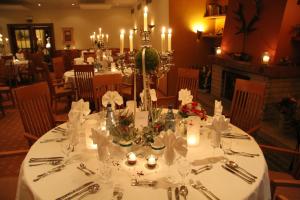 un tavolo da pranzo con una tovaglia bianca e candele di Landhaus Hirschsprung a Detmold