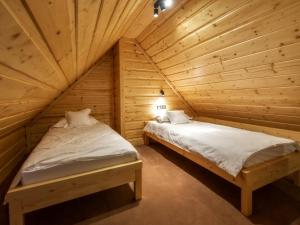 dwa łóżka w pokoju z drewnianymi ścianami w obiekcie Apartamenty 58 Czarny Groń w mieście Rzyki