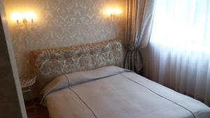 ein kleines Schlafzimmer mit einem Bett und einem Fenster in der Unterkunft Centro apartamentai - Vingio apartamentai in Vilnius