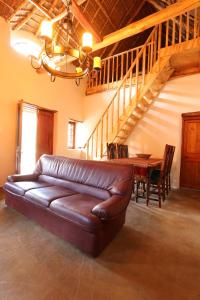 a leather couch in a living room with a table at Matjiesvlei Retreat Oudehuiskloof in Calitzdorp