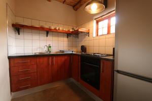 a small kitchen with a sink and a stove at Matjiesvlei Retreat Oudehuiskloof in Calitzdorp
