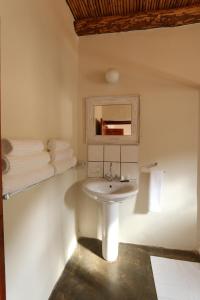 a bathroom with a sink and a mirror and towels at Matjiesvlei Retreat Oudehuiskloof in Calitzdorp
