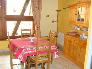 uma cozinha com uma mesa e uma mesa e uma janela em la grange de louis em Turckheim