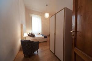a bedroom with a bed and a chair and a window at La Porta del Paradiso in Florence