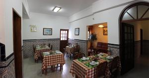 a restaurant with two tables and chairs with plates on them at Ondazul in Zambujeira do Mar
