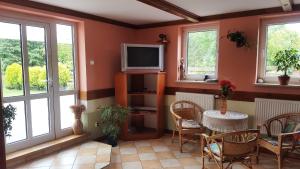 a living room with a television and a table and chairs at Wieża nad Biebrzą in Dolistowo