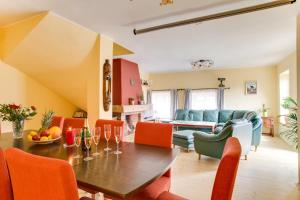 un soggiorno con tavolo in legno e sedie arancioni di Amazing 5 bedroom house KRUMLOV 82 - 4 min walk to main square a Cesky Krumlov