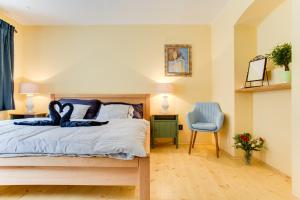 sypialnia z łóżkiem i niebieskim krzesłem w obiekcie Amazing 5 bedroom house KRUMLOV 82 - 4 min walk to main square w Czeskim Krumlovie