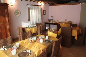 a dining room with tables and chairs with yellow table cloth at Villa Collio Relais in San Severino Marche