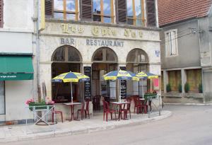 a group of tables and chairs with umbrellas outside a building at Les Epis d'Or in LʼIsle-sur-Serein