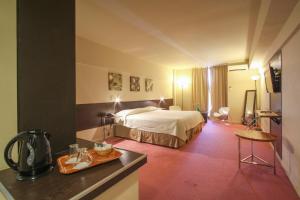 ブエノスアイレスにあるウノ ブエノスアイレス スイーツのベッドとテーブルが備わるホテルルームです。