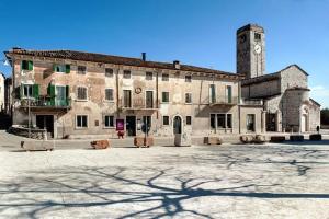 un gran edificio con una torre de reloj en un patio en La Grande Casa Valpolicella, en SantʼAmbrogio di Valpolicella