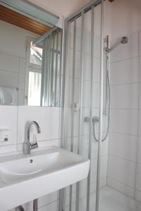 a white bathroom with a sink and a shower at Adler Post in Lenzkirch
