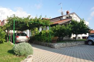 a house with a car parked in front of it at Franko Apartmani in Zambratija