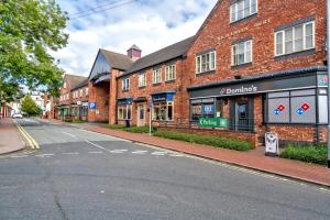an empty street in front of a brick building at Cannock Hotel Apartments in Cannock