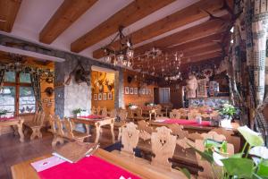 a dining room with tables and chairs and a chandelier at BILÍKOVA CHATA - Horský hotel in Starý Smokovec
