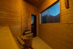 a bathroom with a wooden floor and wooden walls at Mountain Hotel Bilíkova Chata in Vysoké Tatry