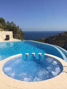 a large swimming pool with a view of the ocean at Villa Priscilla in Jávea