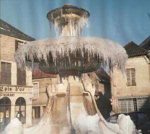 Una fuente de agua con hielo encima. en Les Epis d'Or, en LʼIsle-sur-Serein