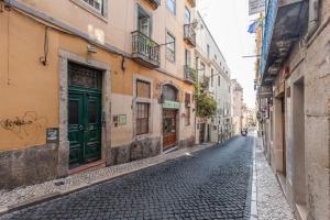 a cobblestone street in an alley with buildings at Casa da Rua do Norte in Lisbon
