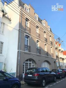 un bâtiment avec des voitures garées devant lui dans l'établissement Le Studio 12, à Le Touquet-Paris-Plage