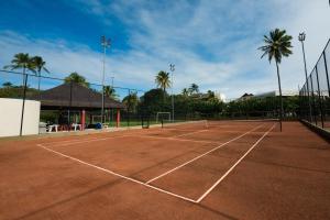 a tennis court with palm trees in the background at Marulhos Suítes Resort by MAI in Porto De Galinhas