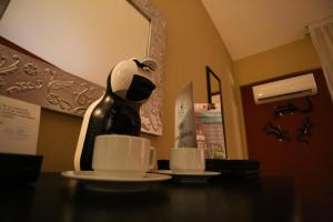 a coffee maker sitting on a table with two cups at Hotel Montetaxco in Taxco de Alarcón