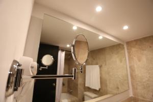 a bathroom with a large mirror and a sink at Hotel Montetaxco in Taxco de Alarcón