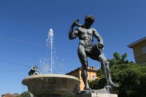 a statue of a boy and a dog next to a fountain at Hotel San Geminiano in Modena