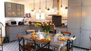 a kitchen with a table with flowers on it at Maison De La Tour in Antibes
