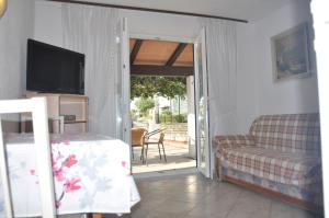 a living room with a couch and a television at Franko Apartmani in Zambratija