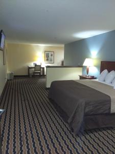 Habitación de hotel con cama grande y escritorio. en Expo Inn en Tulsa