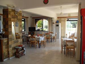 a dining room with tables and chairs and a kitchen at Vera Studios in Faliraki