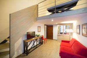 フィレンツェにあるMDR NumberSix Suitesのリビングルーム(赤いソファ、テレビ付)