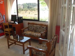 a living room with a couch and a table and a window at Vera Studios in Faliraki