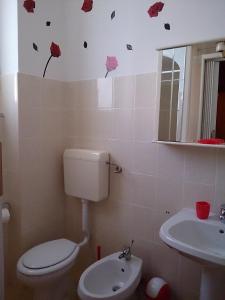 baño con aseo y lavamanos con mariposas en la pared en B&B La Casita en Chieti