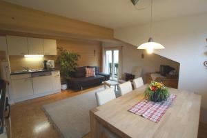 uma cozinha e uma sala de estar com mesa e cadeiras em Familienbauernhof Köss Schertler em Egg