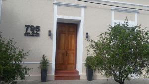 una casa con una puerta de madera en un lado en Hotel Las Calas, en Paso de los Toros