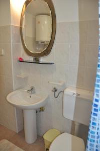 a bathroom with a sink and a toilet and a mirror at Franko Apartmani in Zambratija +40 photos