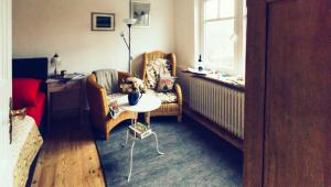a living room with a dog sitting on a chair and a table at Das Blaue Haus in Husum