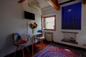 una habitación con sillas y una mesa con un jarrón de flores en Mansardina San Marco, en Venecia 15 fotos más