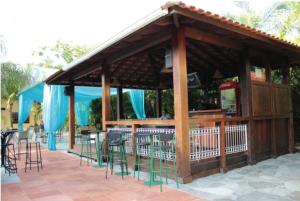 a pavilion with a bar with chairs and tables at Mariá Plaza Hotel in Araçatuba