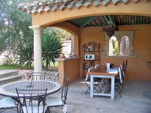 Un patio con una mesa y sillas en un patio. en Sous les pins, en Nages-et-Solorgues