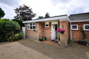 a brick house with a white door and flowers at Saurden Guest Apartment in Ipswich