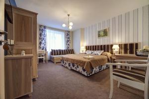 Habitación de hotel con cama y sofá en Pensjonat Kościuszko, en Krynica-Zdrój