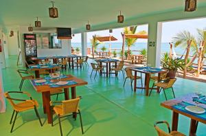 a restaurant with tables and chairs and the ocean at Punta Pico in Bocapán